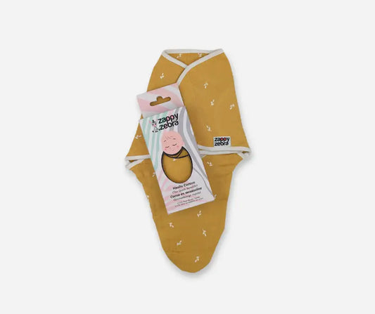 Yellow ochre muslin baby cocoon swaddle with white trim and packaging on white background