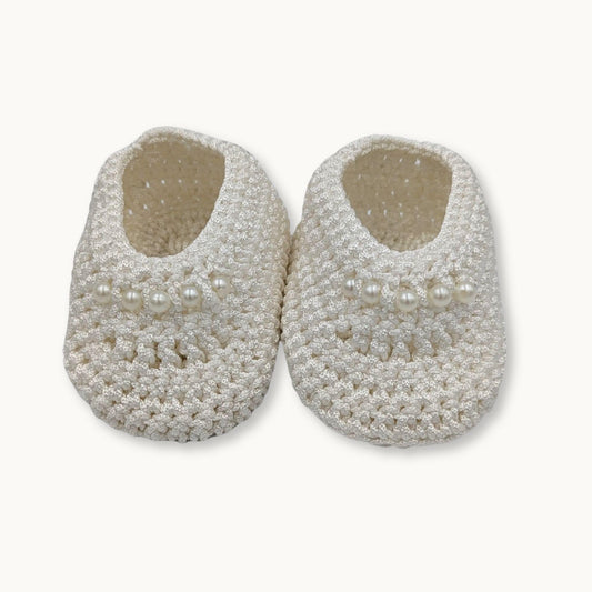 Pair of beaded baby shoes with pearls on a white background