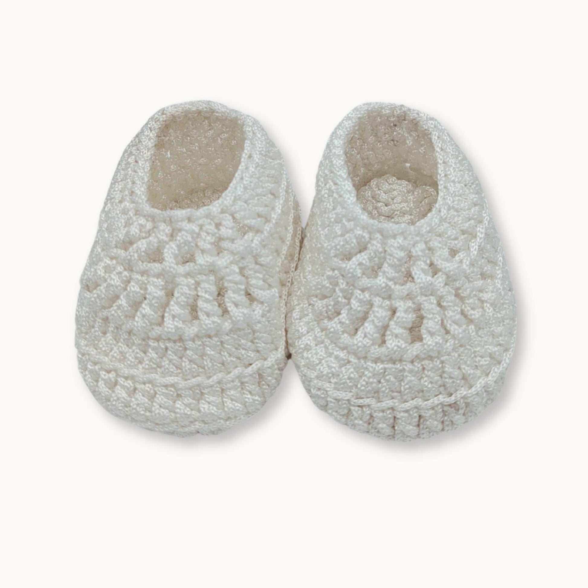 Pair of white textured slippers on a light beige background