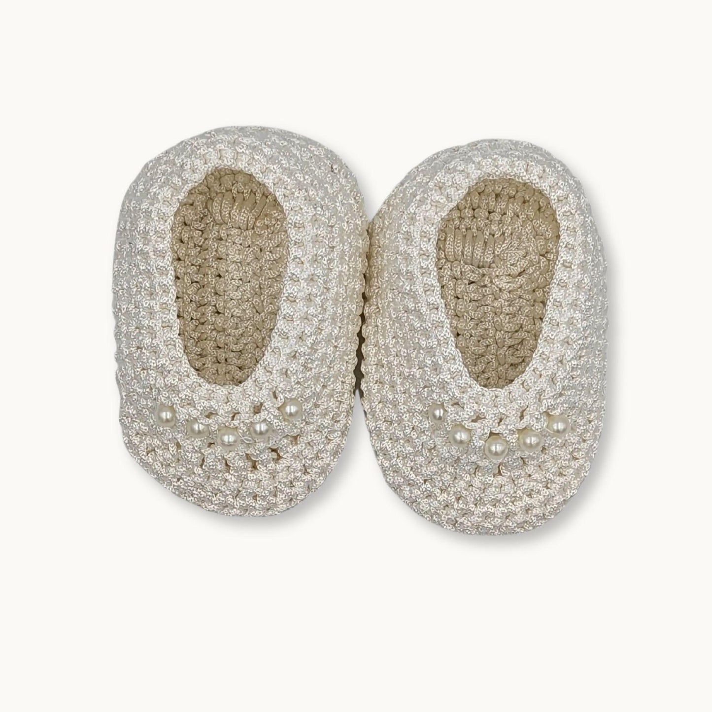 Pair of silver beaded shoes on a white background
