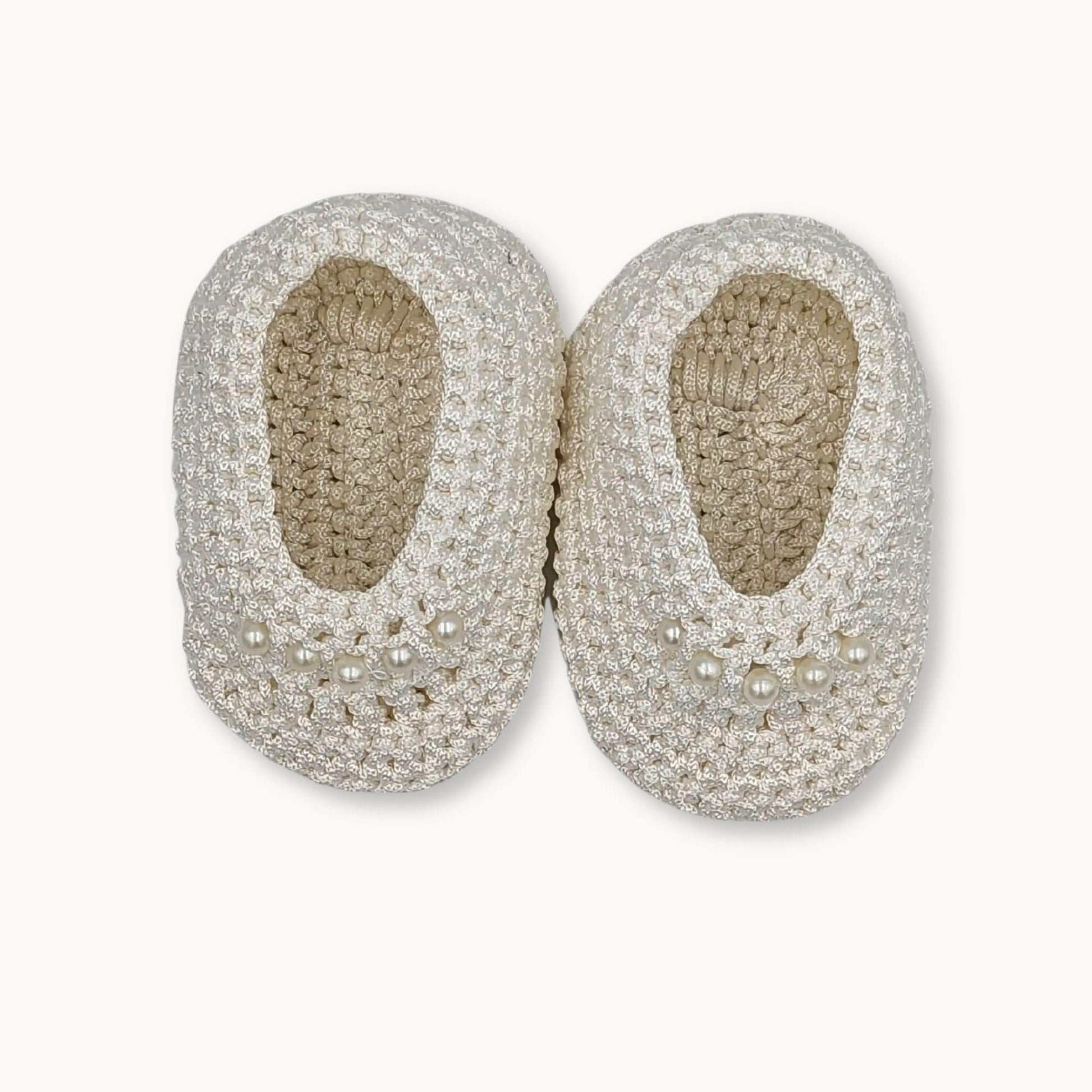 Pair of silver beaded shoes on a white background